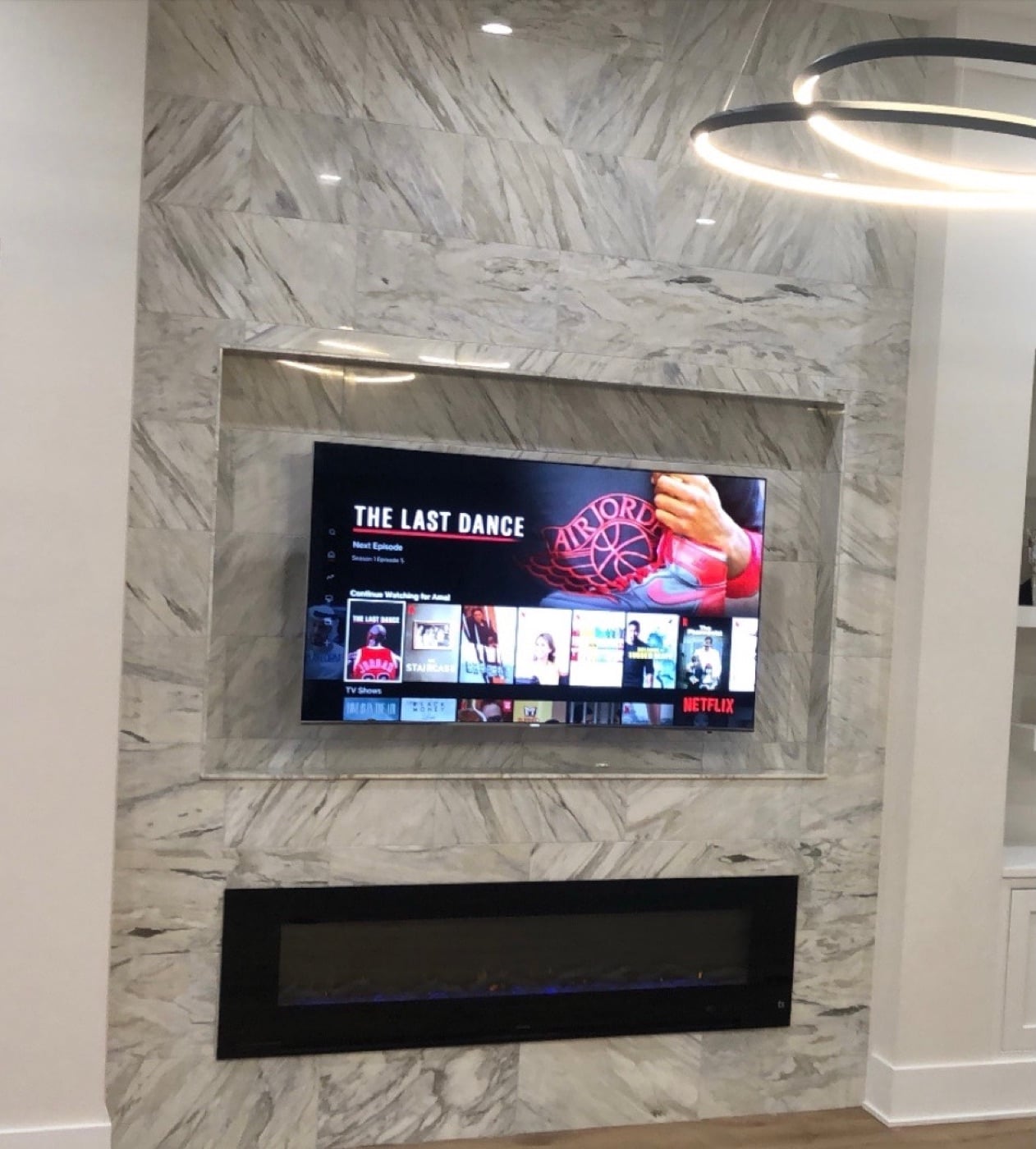 TV mounted over a marble fireplace with concealed wiring